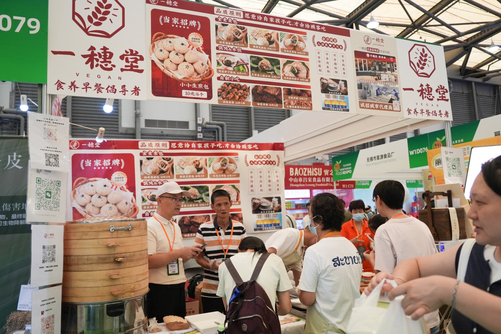 Visitors gathered at the Yisuitang booth, with bamboo steamers and food displays in the foreground.